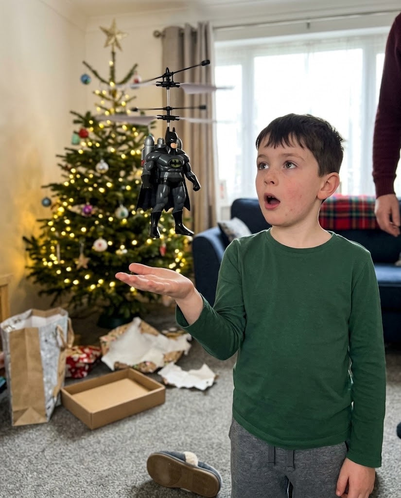 Child flying the Batman FlyHero Pro indoors in a living room
